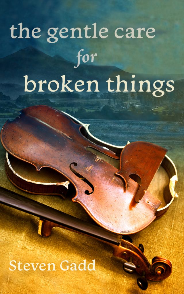 Coiver image for The Gentle Care for Broken Things. In the foreground is a broken violin lyin gon gold-coloured linen, and in the background is a faded image of the Tasmanian town of Dover and the moutain Adamson's Peak, in dark ble and teal tones.